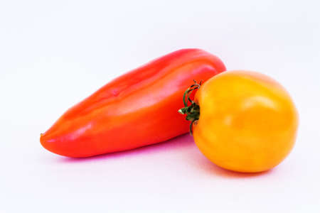 red pepper and yellow tomato on a white backgroundの写真素材