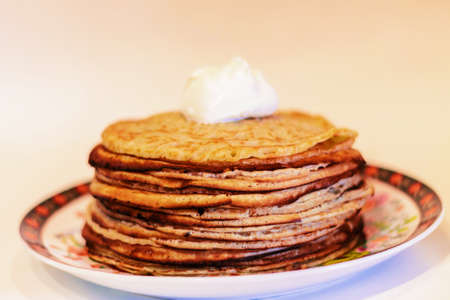 pancakes with sour cream on a white background