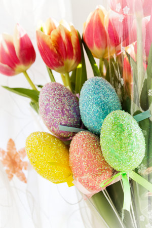 Colorful Easter eggs with close-up tulips. Festive background.の写真素材