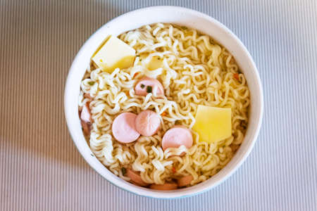 Chinese noodles with cheese and sausages brewed in a bowlの写真素材