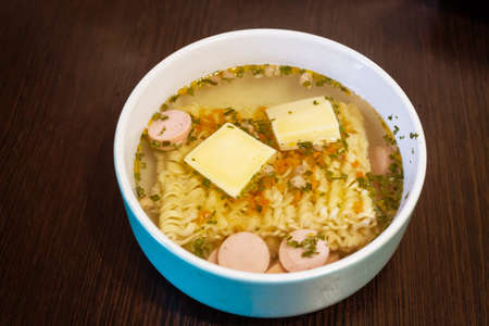 Chinese noodles with cheese and sausages brewed in a bowlの写真素材