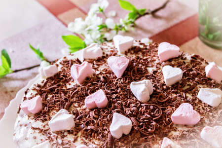 Festive cake with cream and chocolate, decorated with hearts close-up.の写真素材