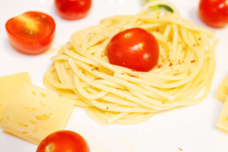 Spaghetti with cherry tomatoes and cheese on a plate close-upの写真素材