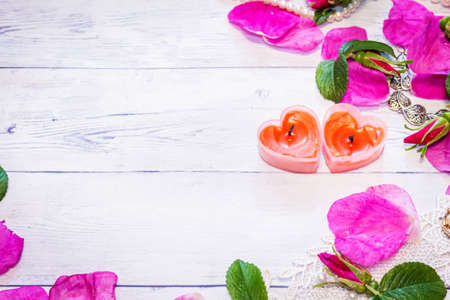 Romantic background. On a white sheet rose petals, decorations and candles close-up.の写真素材
