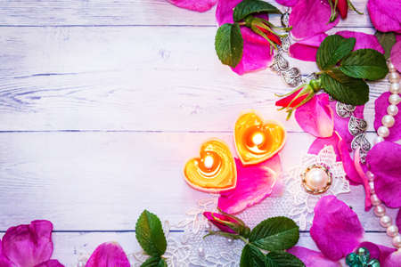 Romantic background. On a white sheet rose petals, decorations and candles close-up.の写真素材