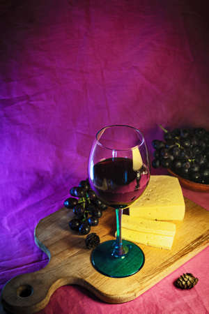 A glass of red wine with cheese and grapes close-up.の写真素材