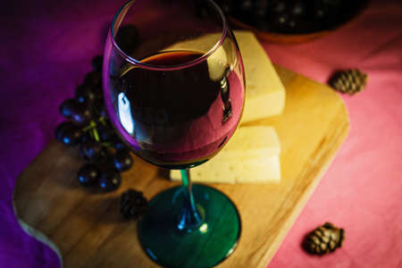 A glass of red wine with cheese and grapes close-up.の写真素材