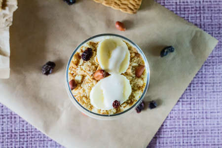 Delicious and healthy yogurt dessert with banana, biscuits and nuts.の写真素材