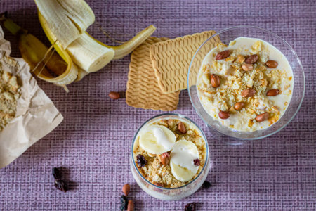 Delicious and healthy yogurt dessert with banana, biscuits and nuts.