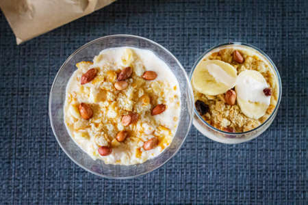 Delicious and healthy yogurt dessert with banana, biscuits and nuts.の写真素材