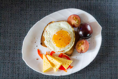 Delicious and healthy breakfast. Scrambled eggs on a toaster with cheese and tomatoes.の写真素材