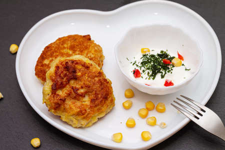 Delicious catlets on a plate with sauce of sour cream and greens close-up.の写真素材