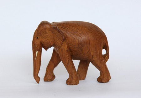 Wooden handmade elephant statue isolated on white is waling in Africaの写真素材