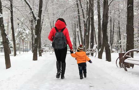 mother and little boy walking in winter parkの写真素材
