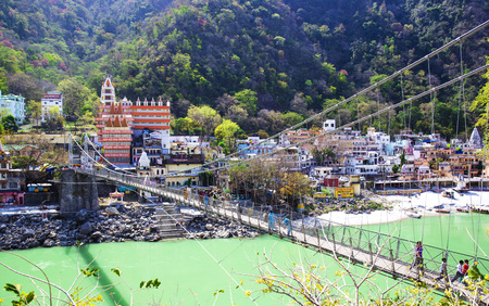 RISHIKESH, INDIA - April 03, 2014 - The main view to Ganga river, bridge and temple.のeditorial素材