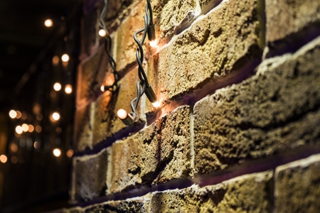 brick wall Christmas background with lights glowingの写真素材