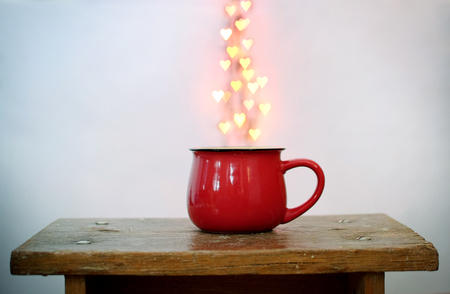 Red cup and heart shaped bokeh over it on white background. Valentines Day conceptの写真素材