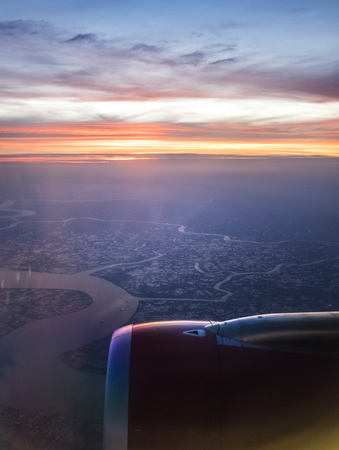 Wing of airplane flying above clouds at beautiful sunset.の写真素材