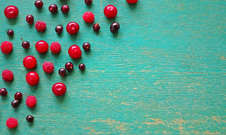 Ripe berries on a blue wooden background
