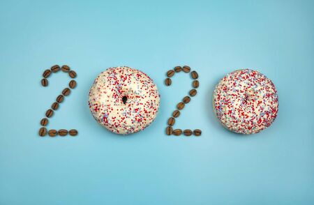 New year 2020 made of donuts and coffee beans on the blue background.の写真素材