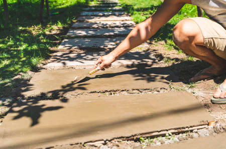 Making concrete slab walkway set on green grassの写真素材