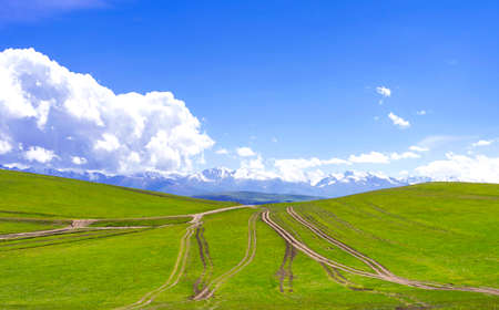 Summer landscape with green hills and dirt roads. Plateau Assy, Kazakhstanの写真素材