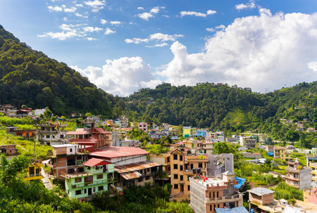 View of colorful buildings surrounded by green mountains, Kathmandu, Nepal.