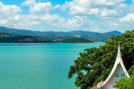 Beautiful view from the hill to Koh Samui. Triangular roof, turquoise sea and green mountainsの写真素材