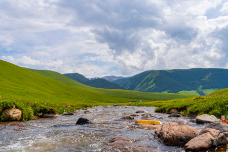 Beautiful nature of Kazakhstan on the Assy plateau in summer. Mountain river, green hills and white...