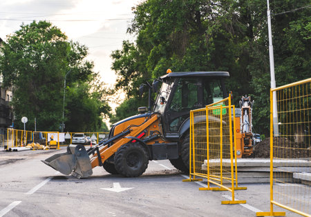 Excavator on a city road. Road work, reconstruction of the underground pipe system.の写真素材