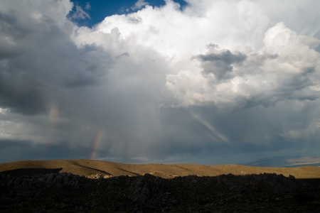 Rainbow over hillsideの写真素材