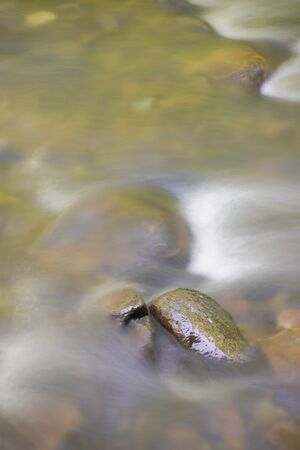 Water motion blur in a creek with rocks in a vertical orientationの写真素材