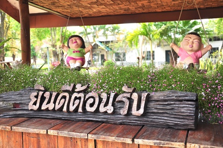 You are welcome in thai word on wood piece  with clay boy&girl dollのeditorial素材