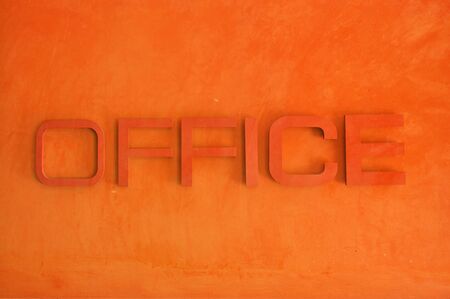 Office text sign on red grunge cement wall, textured background の写真素材