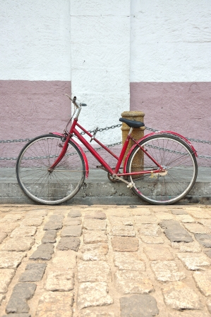 Old red bicycle on ancient streetの写真素材