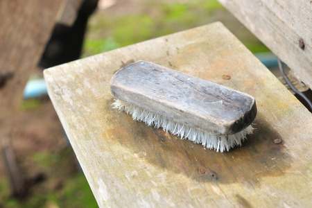 Clothes cleaning brush on wooden background