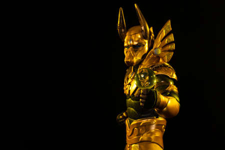 a male actor in a suit of an Egyptian mythology character, the golden deity Jackal Anubis, twists...
