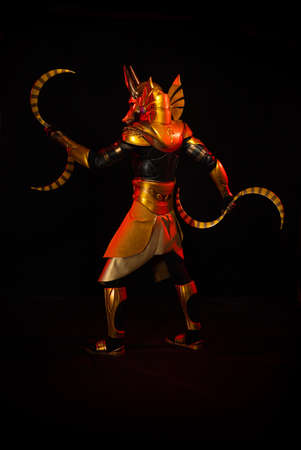 a male actor in a suit of an Egyptian mythology character, the golden deity Jackal Anubis, twists...