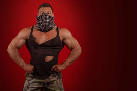 Young male athlete bodybuilder posing on a red backgroundの写真素材