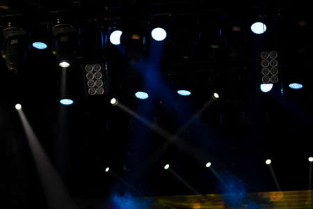 An empty stage of the theater, lit by spotlights and smoke before the performance