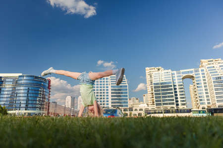 Blonde girl dancing, jumping, doing acrobatics and posing, in the city against the backdrop of...