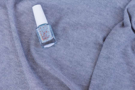 Collection of multi-colored bottles of nail polish. Layout for design on a gray background and a wooden table.の写真素材
