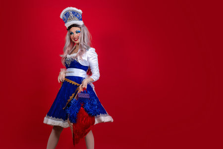 Snow Maiden in an elegant bright blue suit with a crown on his head and gifts in a bag and box...