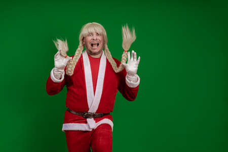 Emotional Santa Claus with long braid hairstyle grimaces and poses on a green chrome background