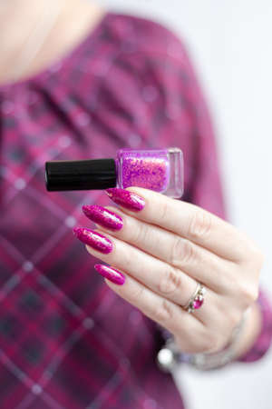 Woman hands with long nails with pink magenta nail polishの写真素材