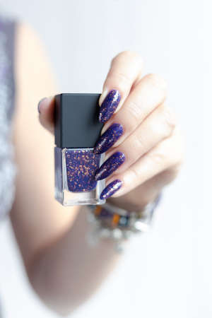 Female hands with long nails with purple nail polish