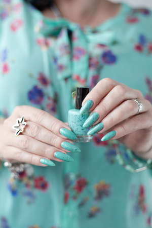 Female hands with long nails with mint green nail polish