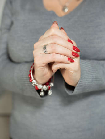 Female hand with long nails and a bottle with red nail polishの写真素材