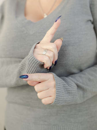 Female hand with long nails and blue manicure with bottles of nail polishの写真素材