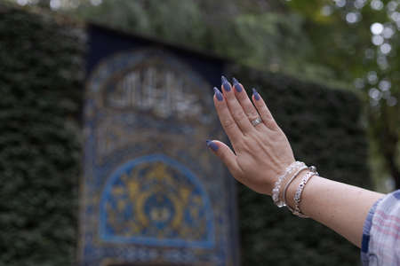 Female hand with long nails and a bottle of blue lilac color nail polish